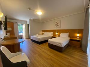 a hotel room with two beds and a table and chairs at Garden Lodge Sydney Hotel in Sydney