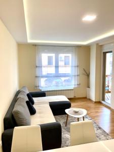 ein Wohnzimmer mit einem Sofa und einem Tisch in der Unterkunft Apartman La Promenade Zlatibor in Zlatibor