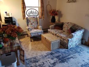 a living room with a couch and two chairs at Mickelson Trail Treehouse Suite in the heart of the beautiful Black Hills in Hill City