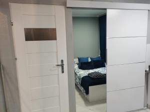- une chambre avec une porte menant à un lit dans l'établissement APARTAMENT BULWAR, à Gorzów Wielkopolski