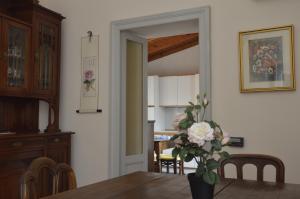 a dining room with a table and a vase of flowers at Pavia Downtown Apartment in Pavia