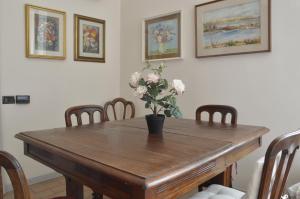 a dining room table with a vase of flowers on it at Pavia Downtown Apartment in Pavia