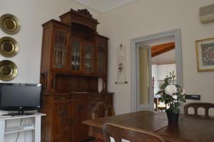 ein Esszimmer mit einem TV und einem Holzschrank in der Unterkunft Pavia Downtown Apartment in Pavia