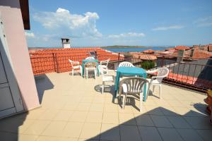 Un patio con mesas y sillas en un tejado. en Guest House Olimpia, en Sozopol
