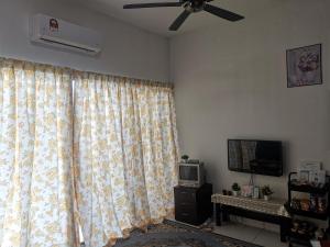 a living room with a ceiling fan and a television at AniS Homestay Nilai USIM KLIA INTI Manipal Nilai 3 in Nilai