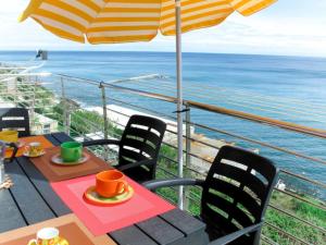 uma mesa e cadeiras com um guarda-sol e o oceano em Casa da Brunetto em Costarainera