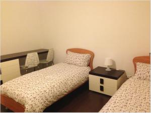 スコリッティにあるResidence Punta d'Angeloのベッドルーム1室(ベッド2台、テーブル、椅子付)
