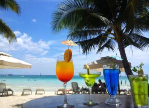 a glass of orange juice sitting on top of a beach at Deparis Beach Resort in Boracay