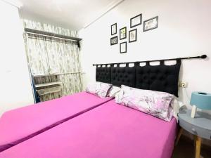 ベニドルムにあるPayma Apartments Benidormのベッドルーム1室(ピンクベッド1台、黒いヘッドボード付)
