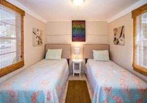 twee bedden in een kamer met twee ramen bij Gulf Shore Cottage - Anna Maria, FL by TS in Anna Maria