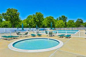 a swimming pool with lounge chairs and a table at Salt Pond -- 13 Skipjack Village in Bethany Beach