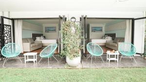 a patio with chairs and a room with beds at Terrigal Pacific Coastal Retreat in Terrigal