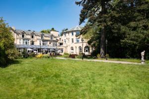 a large building with a grass field in front of it at The Derwentwater Hotel in Keswick