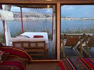 a screened in porch with a view of the water at Uros Qhota Uta Lodge in Puno