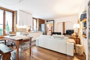 un soggiorno con divano bianco e tavolo di Appartamento Casa Weisstor con patio, giardino e orti vista Monte Rosa a Macugnaga