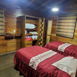 zwei Betten in einem Zimmer mit Holzwänden in der Unterkunft Cabañas Corazón in Troncones + 75 Fotos