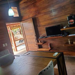 Zimmer mit einer Holzwand, einem Tisch und einem Laptop in der Unterkunft Cabañas Corazón in Troncones