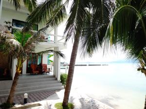 a house on the beach with two palm trees at Neptune's Villa in Haad Rin