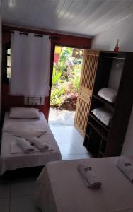 a room with two beds and a door with a window at Bosque dos Esquilos in Abraão