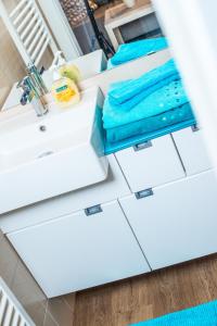 baño con encimeras blancas y toallas azules en Haus Emma en Bad Gastein