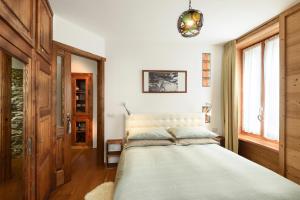 1 dormitorio con cama y ventana en Appartamento Casa Weisstor con patio, giardino e orti vista Monte Rosa, en Macugnaga
