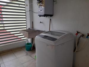 a washing machine in a room with a sink at Departamento completo familias o grupos in Toluca