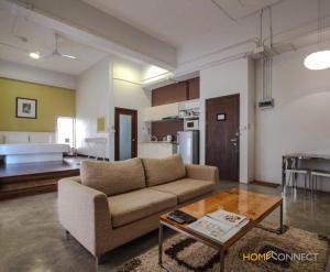 uma sala de estar com um sofá e uma mesa em T Series Place Serviced Apartment em Banguecoque
