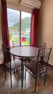 a dining room table with chairs and a large window at La Serrania B&B in Boquete