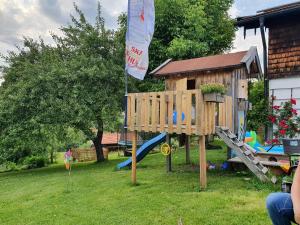 a playground in a yard with a wooden play structure at Haus Matzl inkl. Chiemgaukarte in Ruhpolding