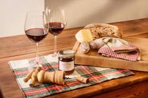 a table with two glasses of wine and bread at Appartamento Casa Weisstor con patio, giardino e orti vista Monte Rosa in Macugnaga +67 photos