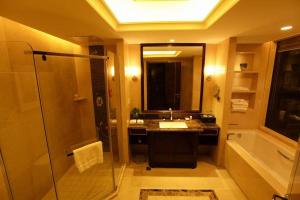 a bathroom with a shower and a sink and a mirror at Ramada Changzhou in Changzhou