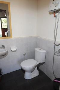 a bathroom with a white toilet and a sink at The Gate Rinjani in Sajang
