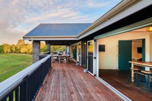 una terraza con mesa y bancos en una casa en HUs - Boutique Venue & Accommodation, en Riverhead