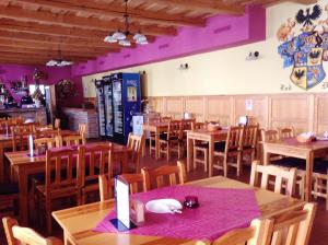 a restaurant with wooden tables and chairs and purple walls at Ubytovanie Anka Sučanská in Čachtice