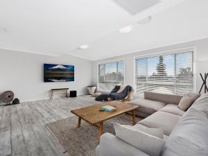 
a living room filled with furniture and a tv at Waterview Beach house in Shelly Beach
