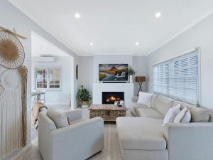 
a living room filled with furniture and a fireplace at Waterview Beach house in Shelly Beach
