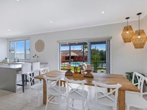 
a kitchen with a table and chairs and a large window at Waterview Beach house in Shelly Beach
