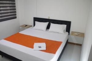 a bedroom with a bed with an orange and white blanket at Hotel Picasso 70 in Medellín +38 photos