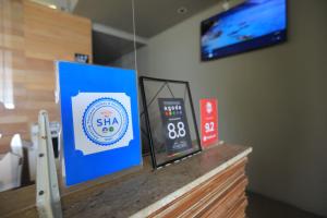 a counter with a sign and a tv on a wall at AKIRA Lipe Resort in Ko Lipe