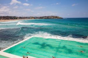 een zwembad op een strand met de oceaan bij Holiday Inn & Suites Sydney Bondi Junction, an IHG Hotel in Sydney