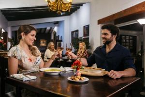 un uomo e una donna seduti a un tavolo con bicchieri da vino di Empedrada Ranch & Lodge - Hotel Asociado Casa Andina a Caral