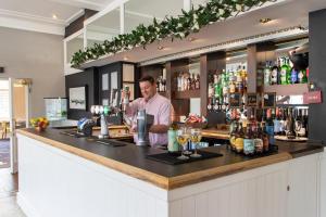 a man standing at a bar with a bartender at The Caledonian New Southlands Hotel in Scarborough