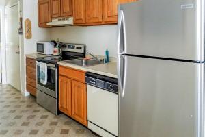 een keuken met een roestvrijstalen koelkast en houten kasten bij Sea Sands 101 in Ocean City