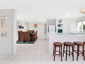 Una cocina con encimera y taburetes en una habitación. en Busselton Beach House with WiFi, en Busselton