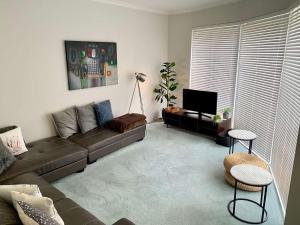 Una sala de estar con un sofá y un televisor. en Busselton Beach House with WiFi, en Busselton