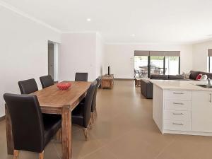 a kitchen and dining room with a wooden table and chairs at Ocean Walk Abbey in Vasse