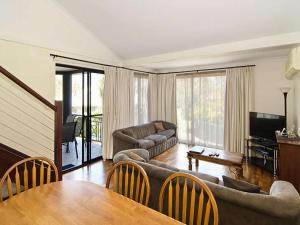 a living room with a couch and a table at Sixteen at Cape View Escapes in Busselton
