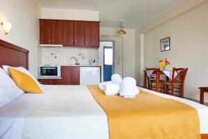 a hotel room with two beds and a television at Olive Bay Hotel in Agia Effimia