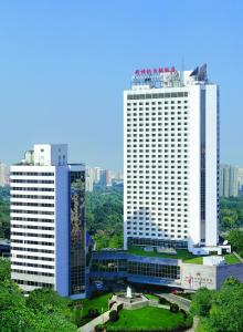 twee hoge witte gebouwen in een stad bij Beijing New Century Hotel in Beijing