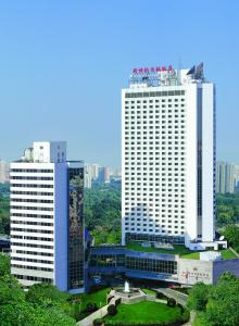 two tall white buildings in a city at Beijing New Century Hotel in Beijing